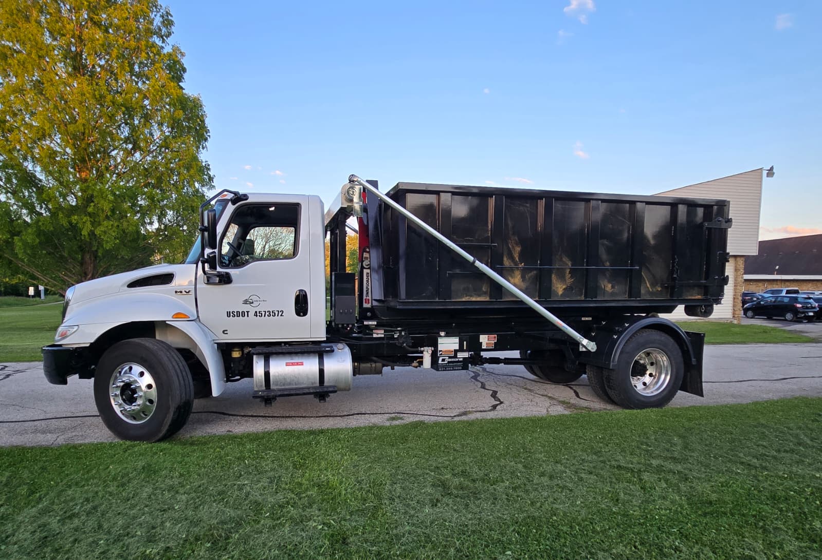 Truck hauling dumpster after pickup